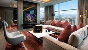 A modern living room with a sofa, armchair, and a flat-screen TV.
