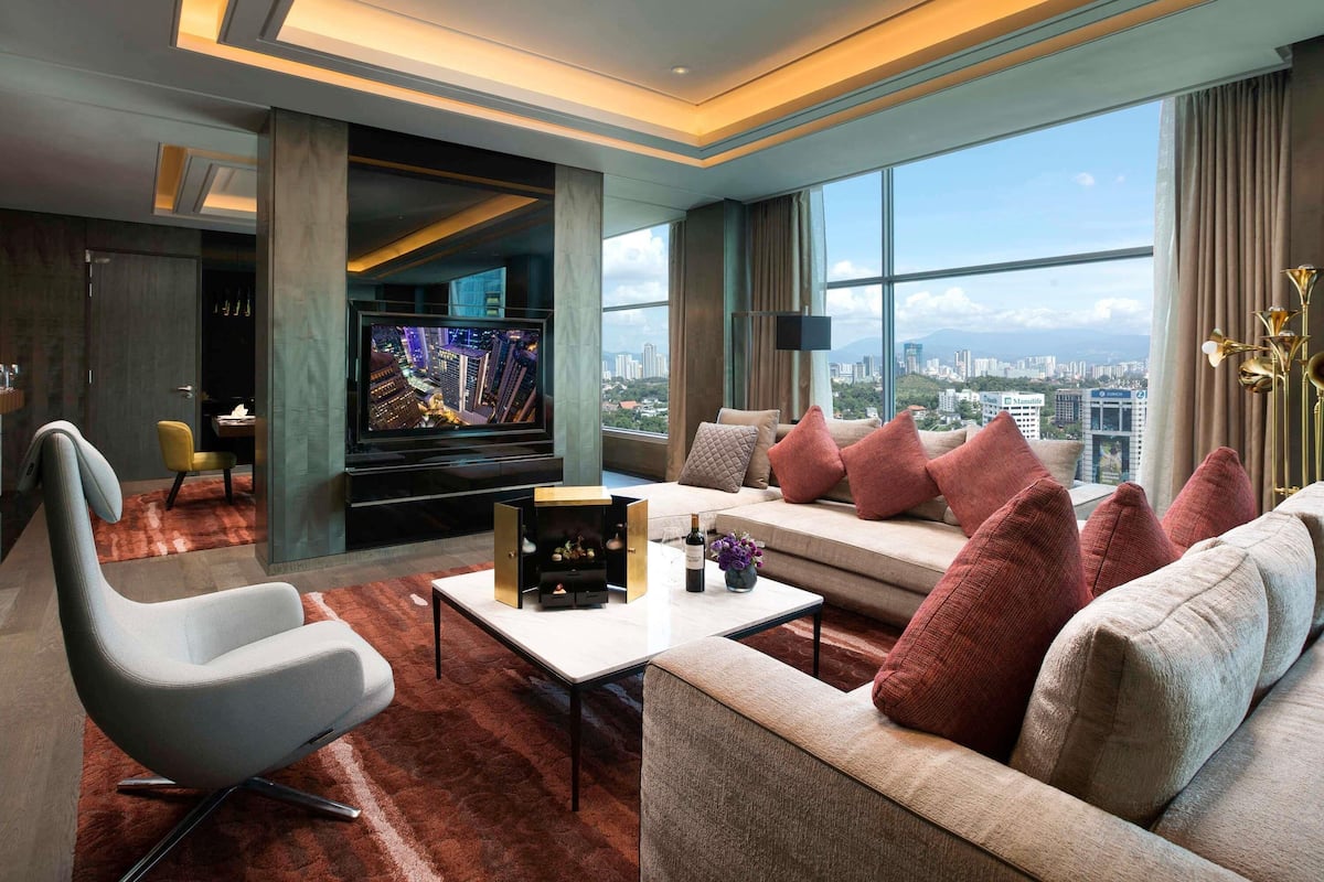 A modern living room with a sofa, armchair, and a flat-screen TV.