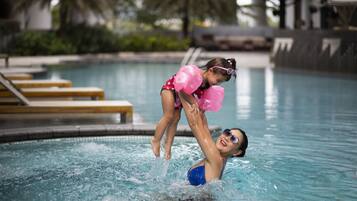 A swimming pool with a person lifting another person.