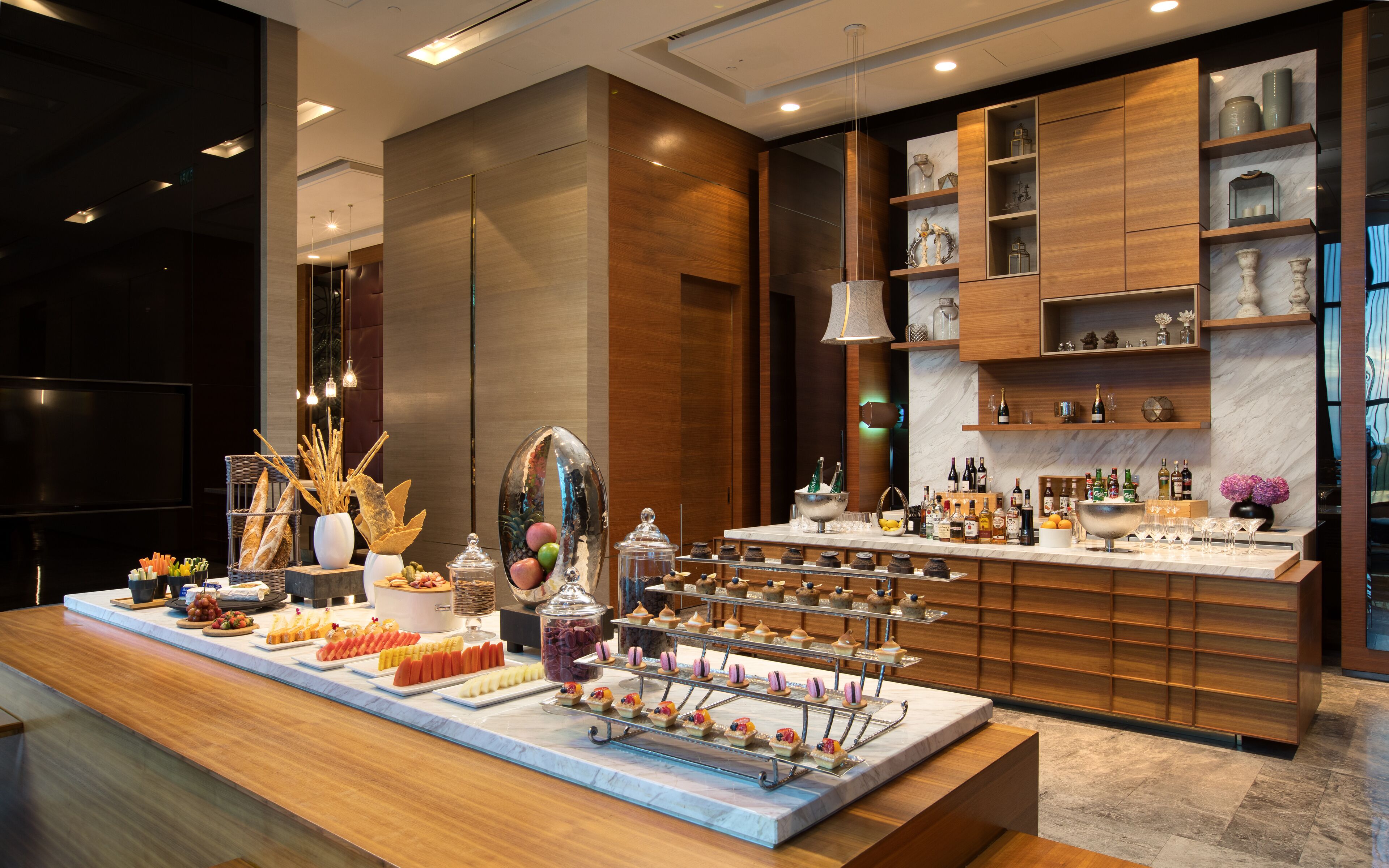 A buffet setup with various food items and a selection of beverages.