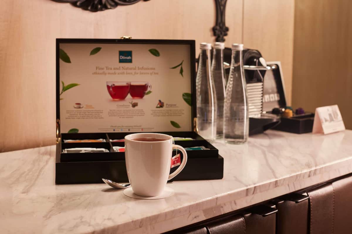 A tea box with a cup of tea on a marble countertop.