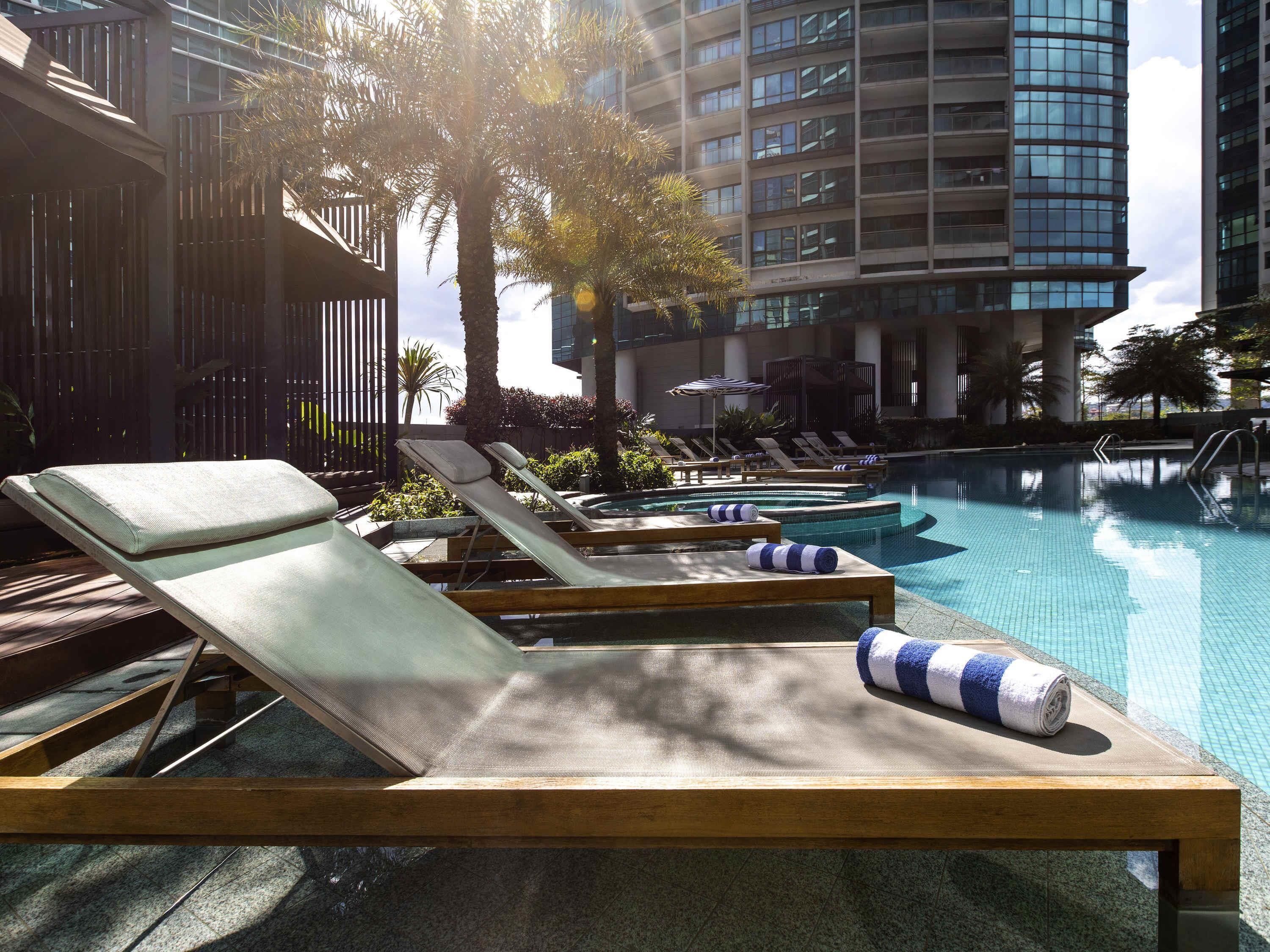 Un espace aménagé au bord de la piscine, avec des chaises longues et une piscine.