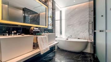 A modern bathroom with a vanity, a large mirror, a bathtub, and a glass shower enclosure.