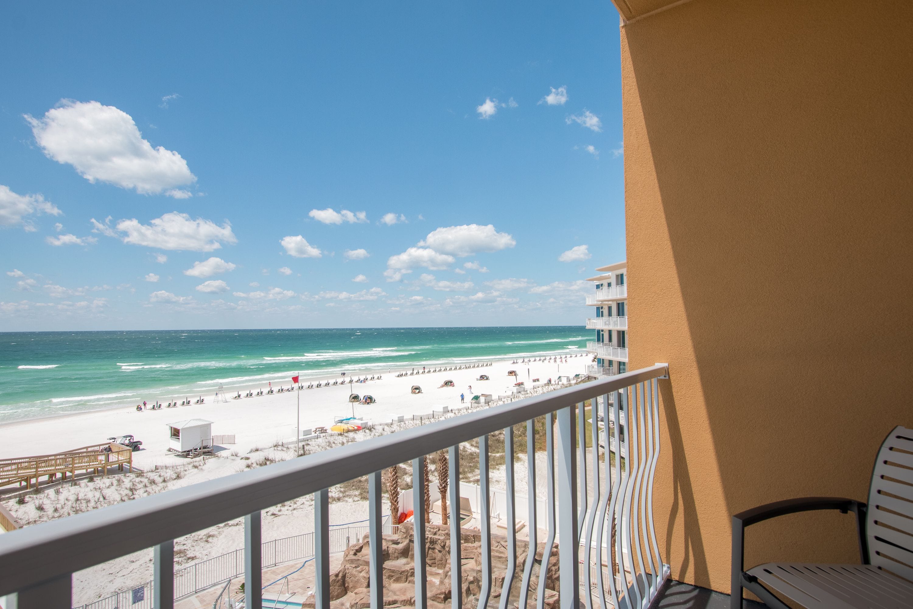 A balcony with a view of a beach and ocean.