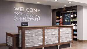 Een receptiegedeelte met een bordje 'Welcome to the Sun Shine State', een minibar en een 'Hilton Honors' bord.
