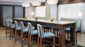 Een vergaderzaal met een lange tafel, zes stoelen en een bank.