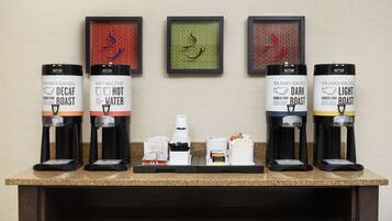 A coffee station with six dispensers labeled Decaf Roast, Hot Water, Dark Roast, and Light Roast.