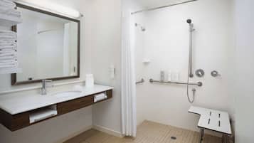 Un baño moderno con un lavamanos, espejo y ducha blancos.