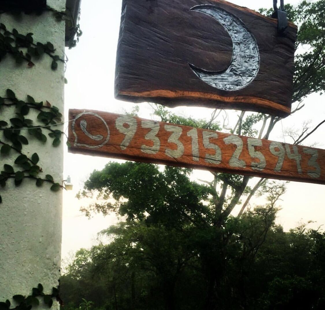 Un letrero de madera con una luna creciente y un número de teléfono.