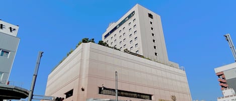 A modern building with a flat roof and a large sign on the ground floor.