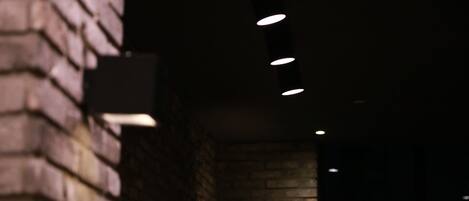 Una pared de ladrillo tenuemente iluminada con una serie de luces empotradas.