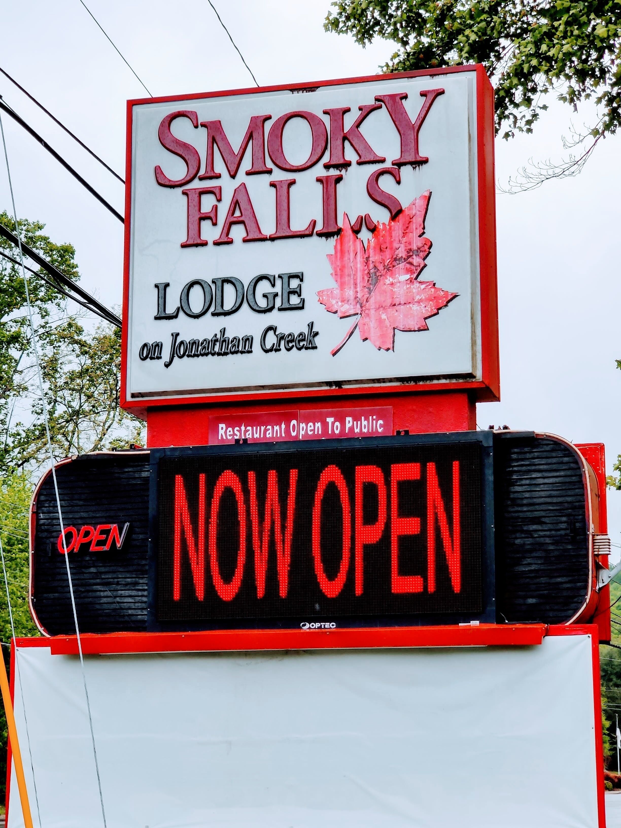A sign for Smoky Falls Lodge on Jonathan Creek, indicating it is a restaurant open to the public.