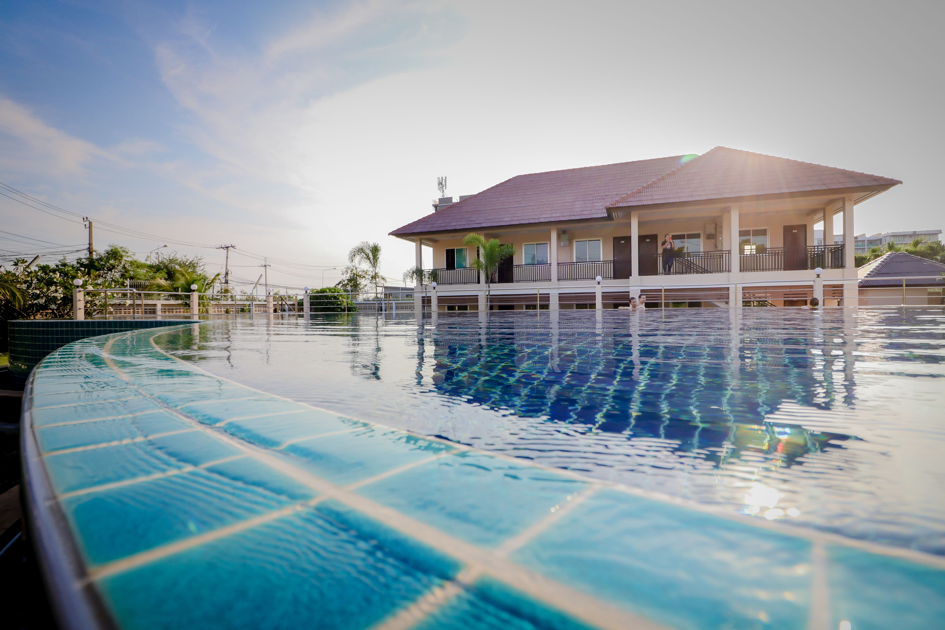 Una piscina al aire libre, sombrillas, sillones reclinables de piscina