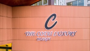 Un bâtiment arborant un logo en forme de « C » bien visible et l’inscription « THE COTAI LUXURY DESIGN » sur sa façade.