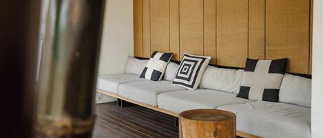 A modern living area with a sofa, pillows, and a wooden table.