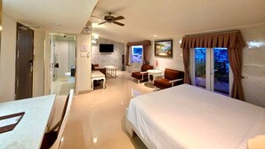 A hotel room with a bed, a desk, a chair, a television, and a view of the outdoors. - Tulip Hotel 3 (Xuan Huong - Da Lat)