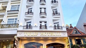 A multi-story hotel with a classic architectural design, featuring balconies and a prominent entrance with a welcoming sign. - Tulip Hotel 3 (Xuan Huong - Da Lat)