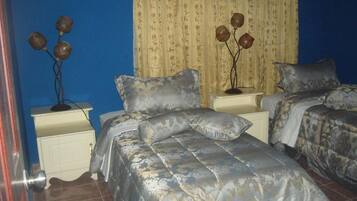A bedroom with two beds, a nightstand, and a decorative vase on the nightstand.