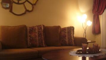 A living room with a sofa, a coffee table, and a wall decoration.