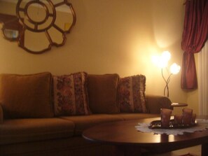 A living room with a sofa, a coffee table, and a wall decoration.