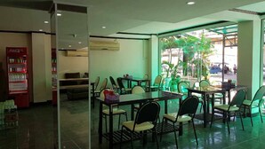 A restaurant with indoor seating, a vending machine, and large windows. - Memory Hotel (Vientiane)