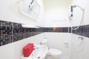 A bathroom with a white sink, toilet, and shower. The walls have a mosaic tile design. - Nittaya Residence (Bangkok)