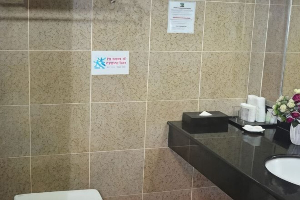 Une salle de bain avec un mur carrelé, un lavabo et un miroir.