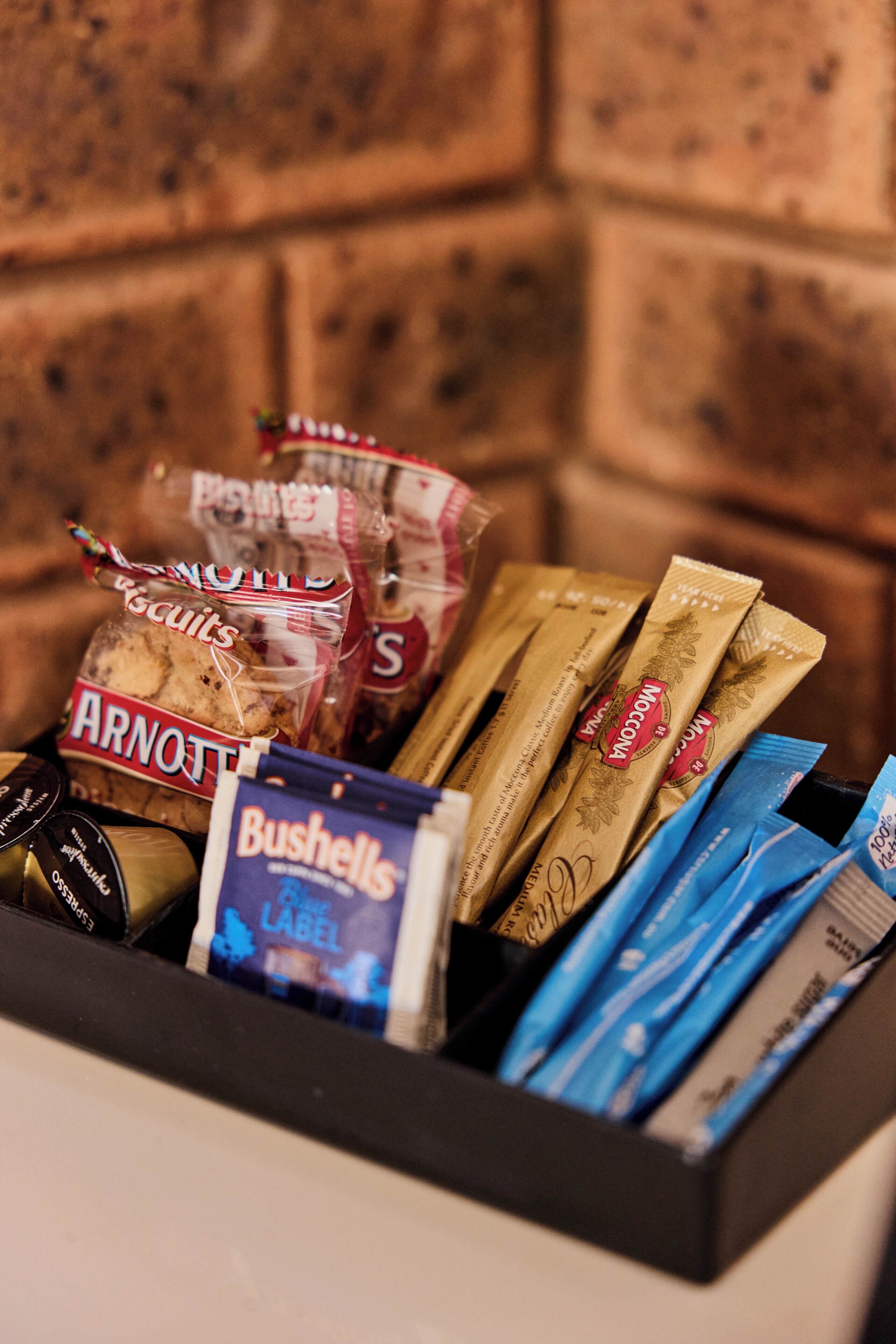 A box containing various packaged snacks and a bottle of wine.