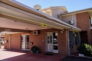 A building with a brick facade, a covered entrance, and a clear sky.