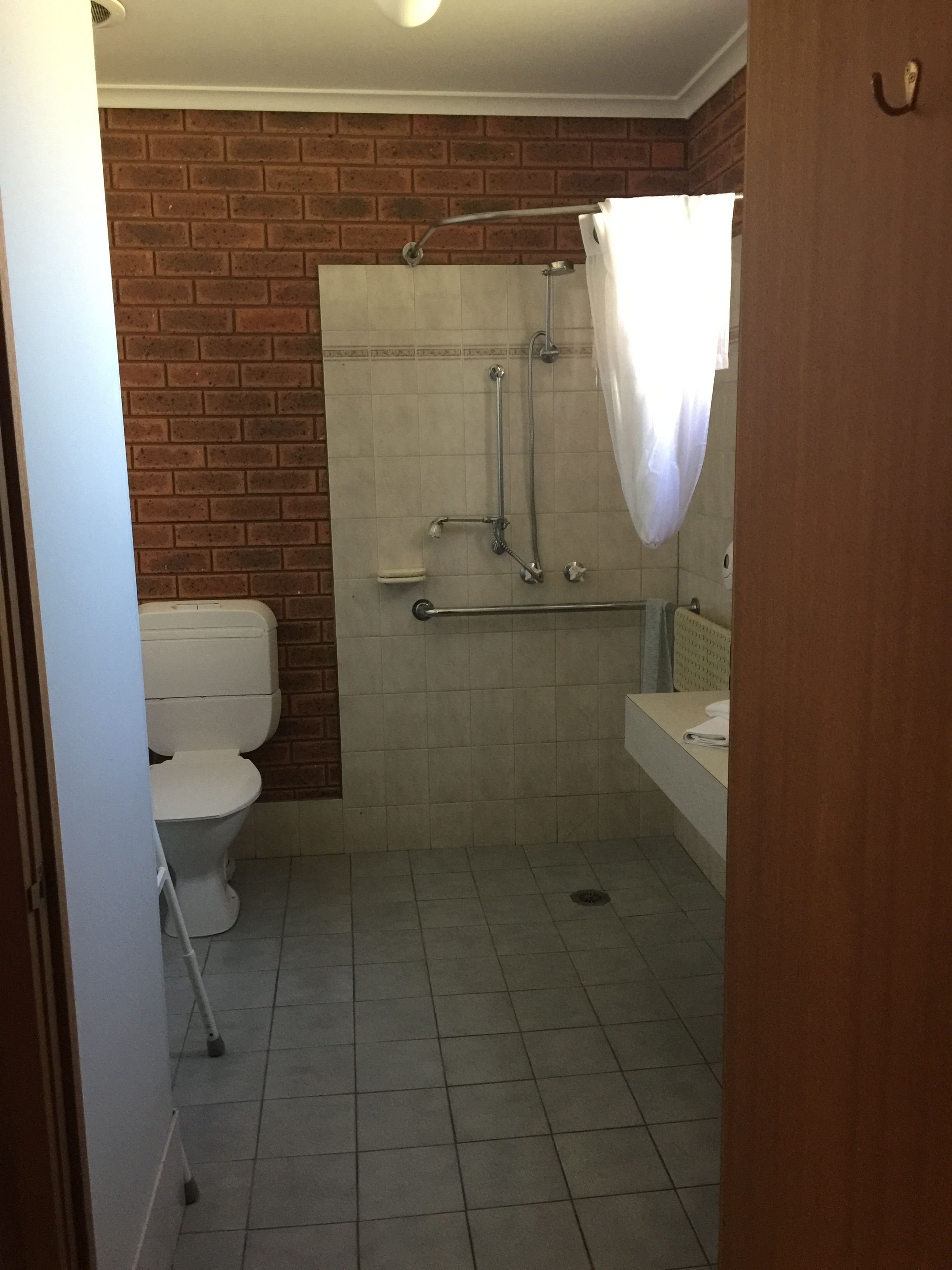 A bathroom with a shower, toilet, and sink.