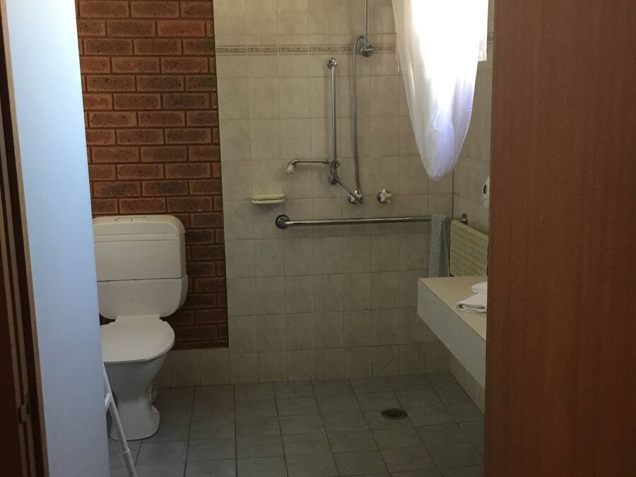 A bathroom with a shower, toilet, and sink.