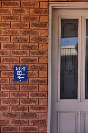 A brick wall with a 'NIGHT BELL' sign pointing left.