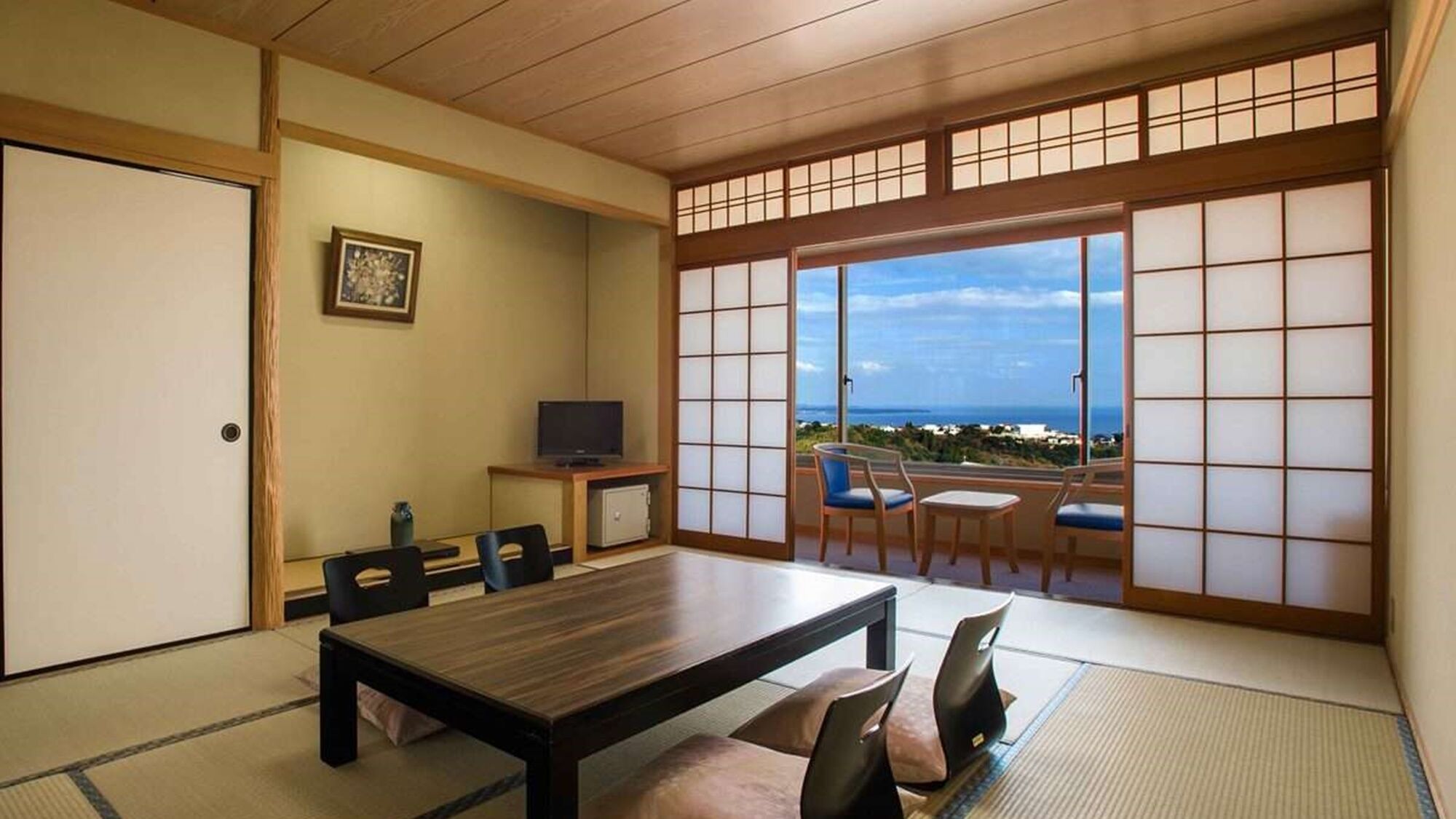 A traditional Japanese-style room with tatami flooring, a low table, and chairs.