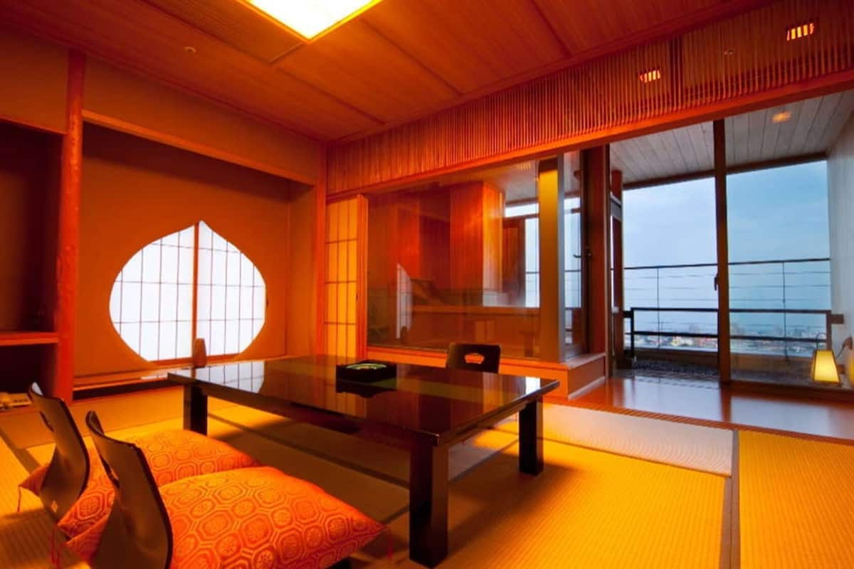 A traditional Japanese-style room with tatami flooring, a low table, and a television.