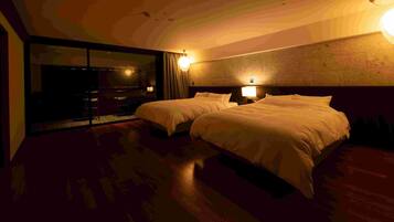 A hotel room with two beds, a large mirror, and a view of the cityscape.