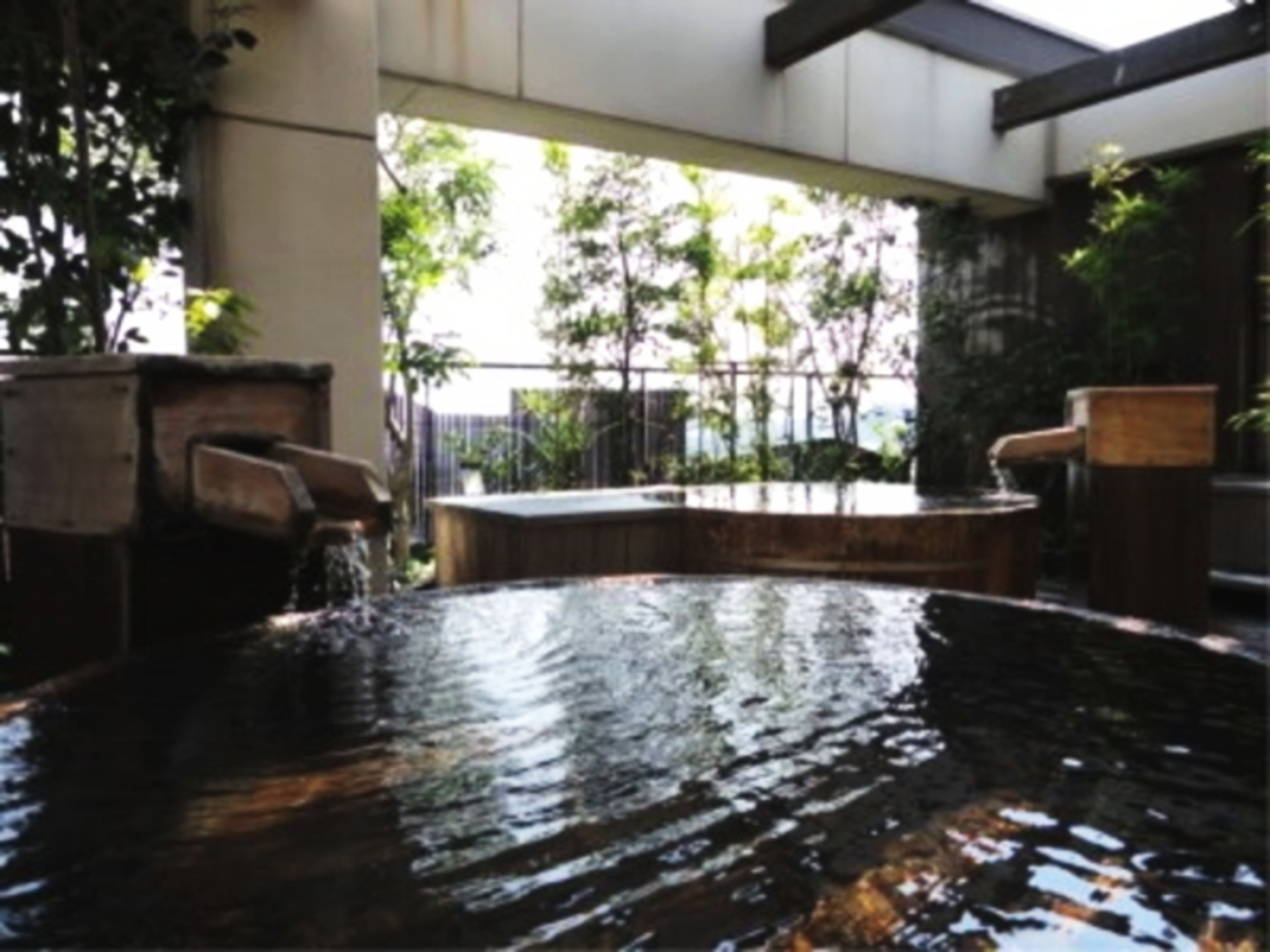 A hot spring area with a wooden bench and a small waterfall.