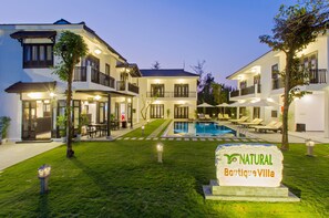 A villa with a swimming pool, outdoor seating, and a sign reading "NATURAL Boutique Villa". - HANZ Natural Boutique Hotel Villa (Da Nang)