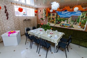 Charming dining area with a mural of a village scene, complete with a beautifully set table and six comfortable chairs.