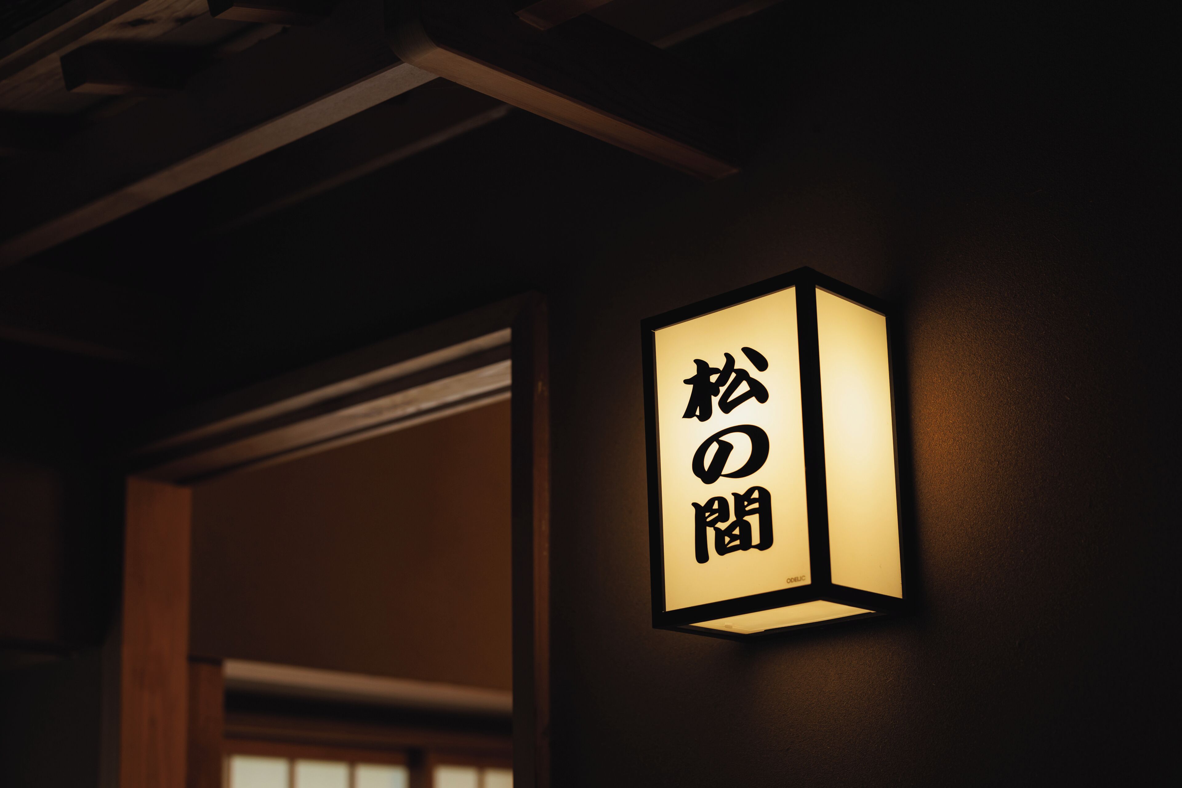 Un letrero sujeto a la pared con caracteres japoneses.