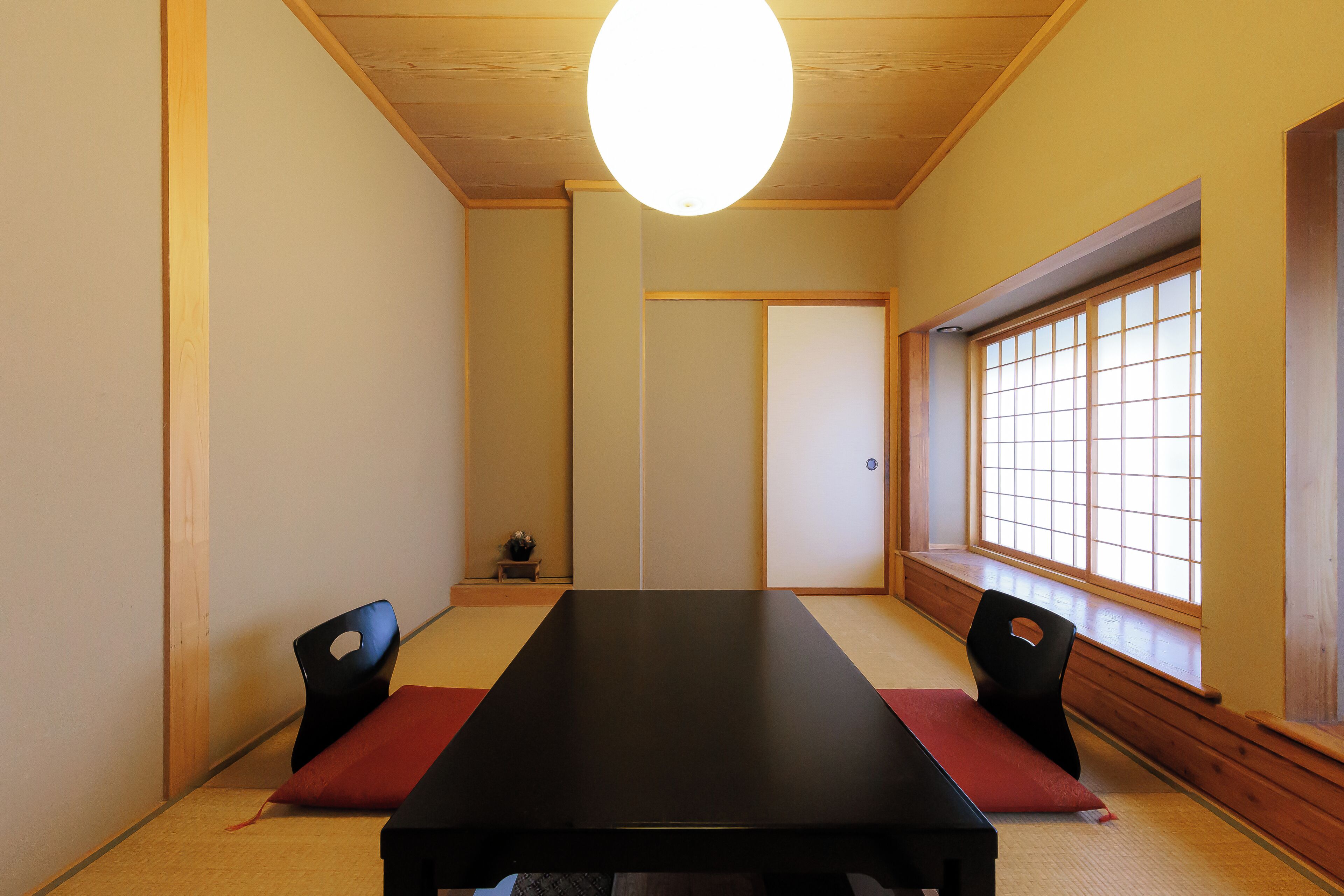 A traditional Japanese room with tatami flooring, a low table, and sliding doors.