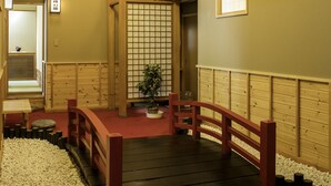 Ein traditionelles japanisches Interieur mit Tatami-Böden, einer Holzbalkendecke und einer Schiebetür.