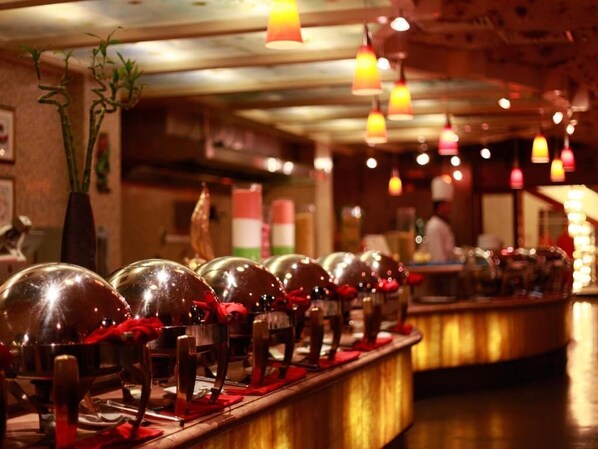 A bar area with multiple shiny, reflective spheres on a counter, warm lighting, and hanging pendant lights.