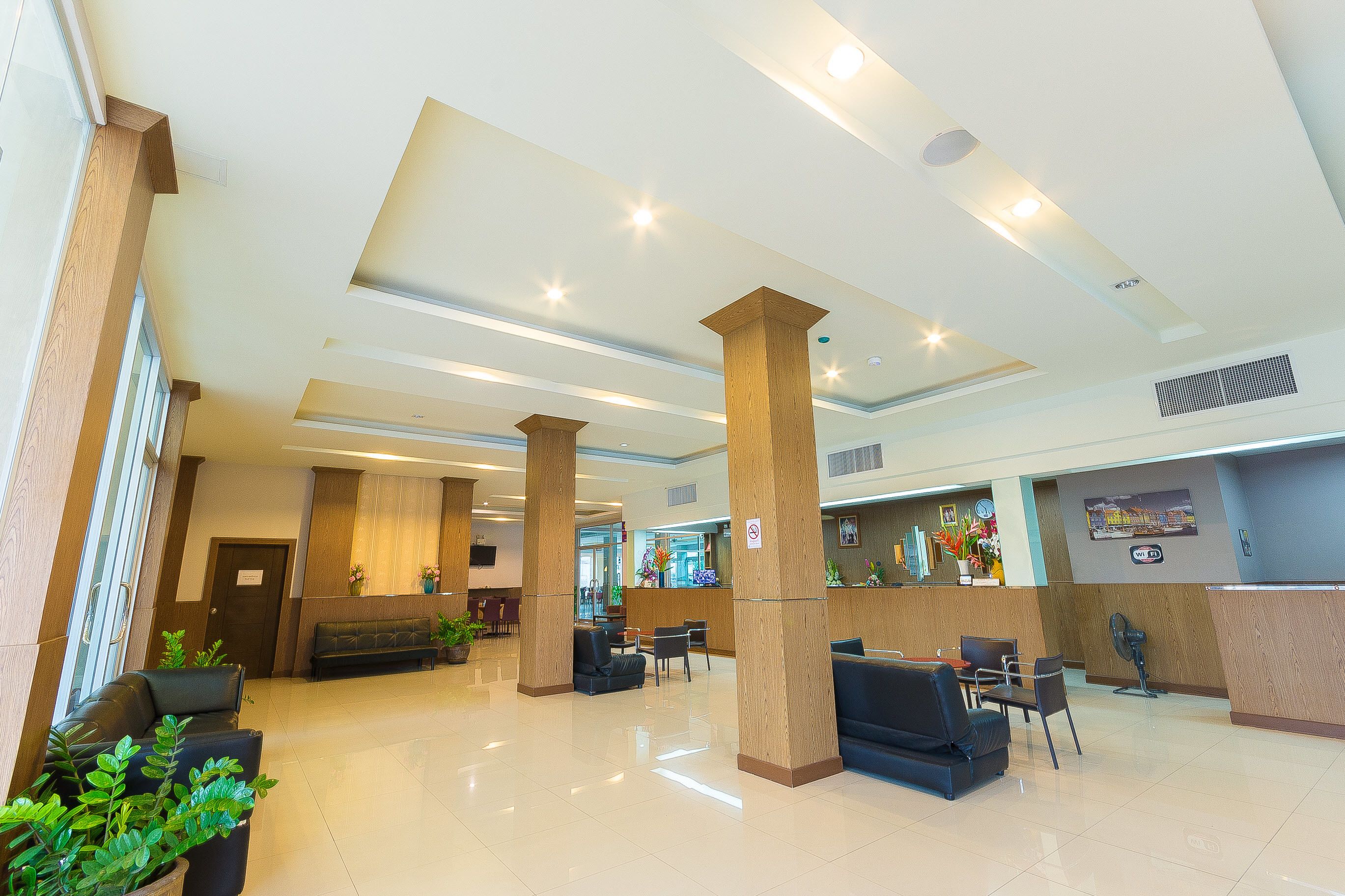 A spacious lobby with high ceilings, large wooden columns, and a reception desk.