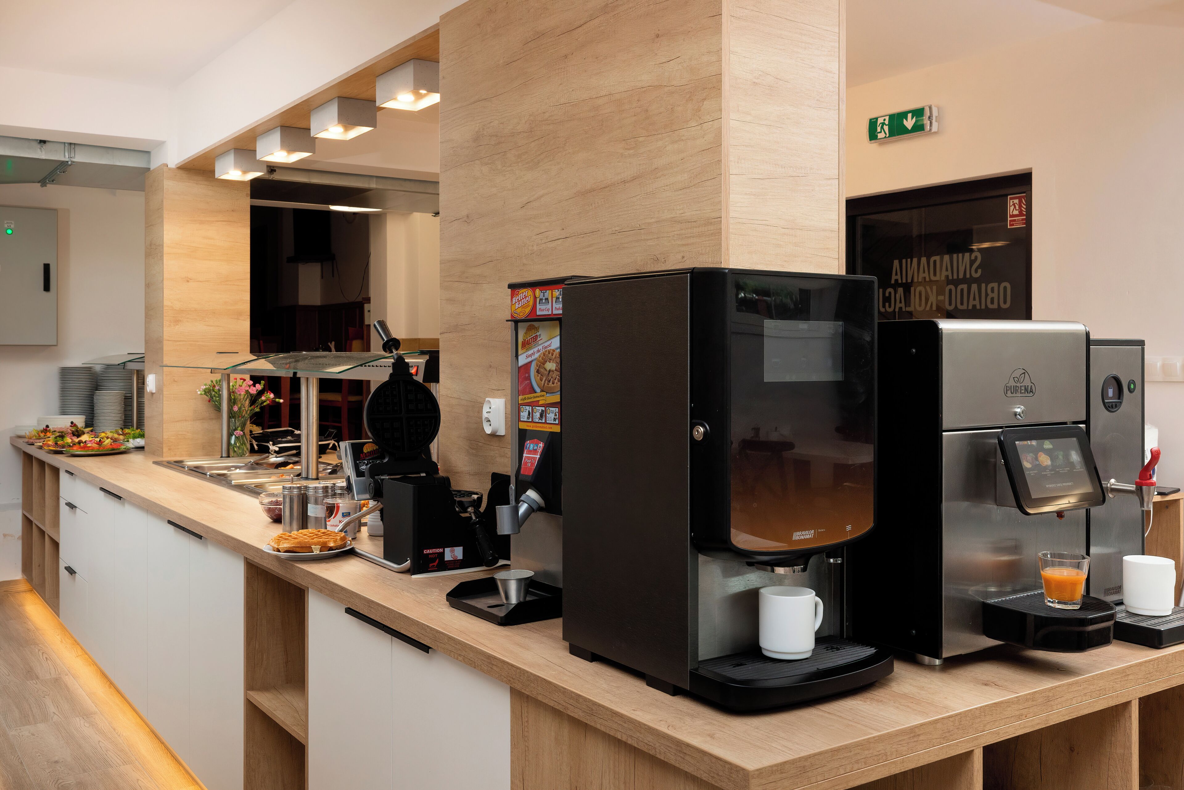 A modern coffee station with multiple espresso machines and a glass display case.