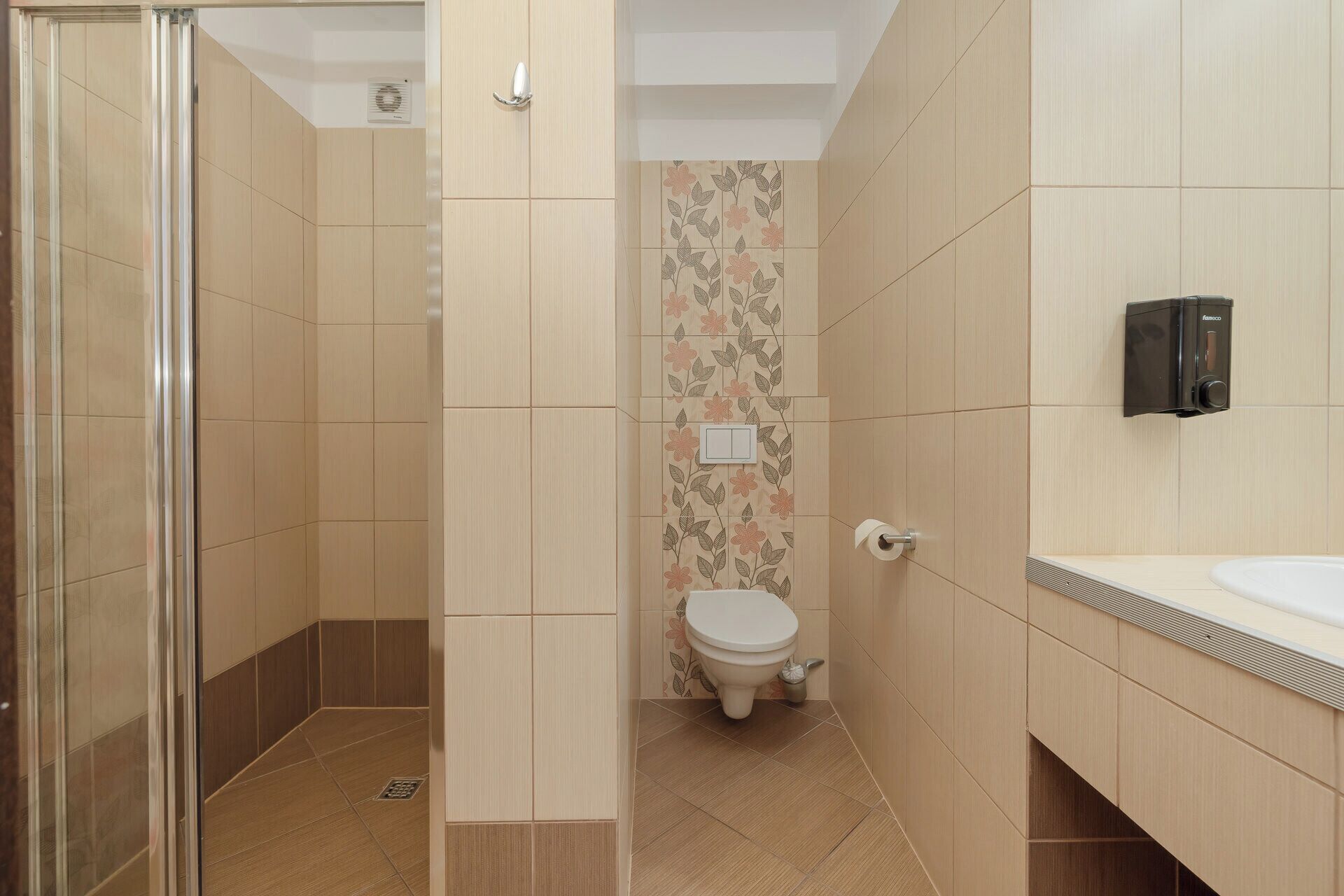 A bathroom with a shower, toilet, and sink.