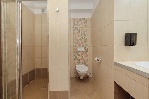 Un baño con ducha, inodoro y lavamanos.