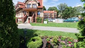 A hotel with a red-tiled roof, a balcony, and a sign reading "Villa Areska." - Willa Florek (Rewal)