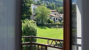 Een balkon met uitzicht op een heuvel en huizen.