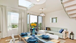 A modern dining area with a wooden table, white chairs, and blue plates.