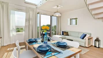 A modern dining area with a wooden table, white chairs, and blue plates.